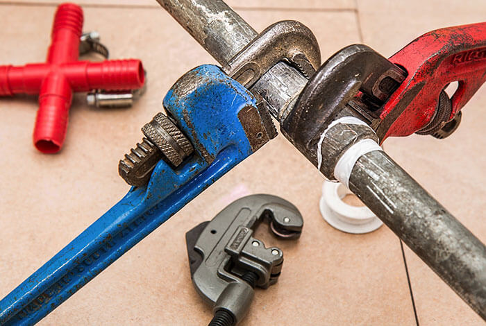 Pipe wrenches and fittings for plumbing repairs